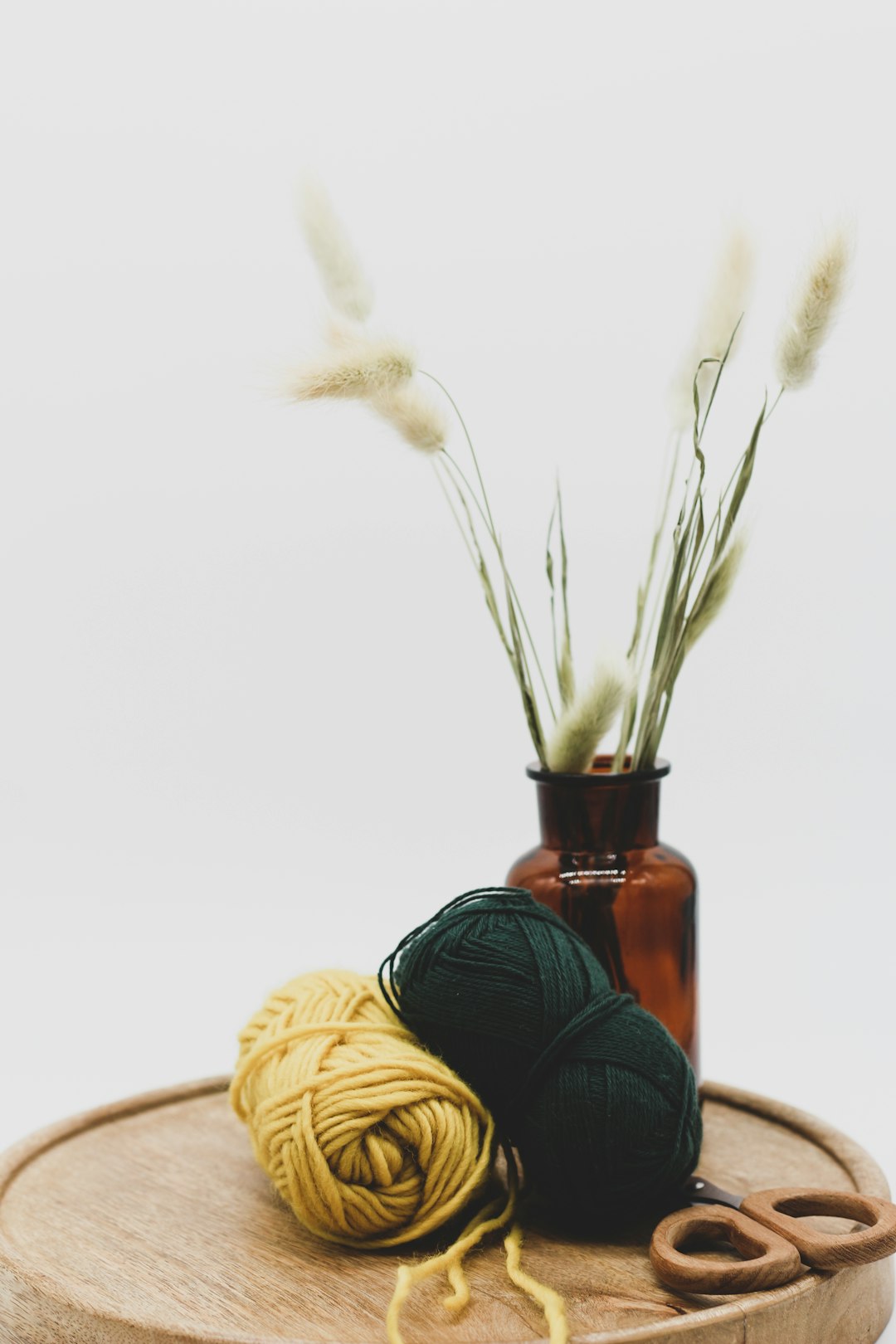 Crochet yarn, hook and scissors arranged on a warm natural craft table