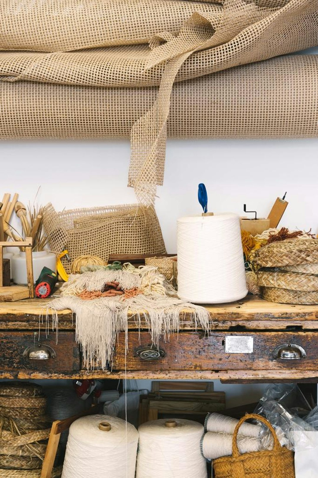 Neutral cotton yarn skeins arranged on a warm wooden craft table