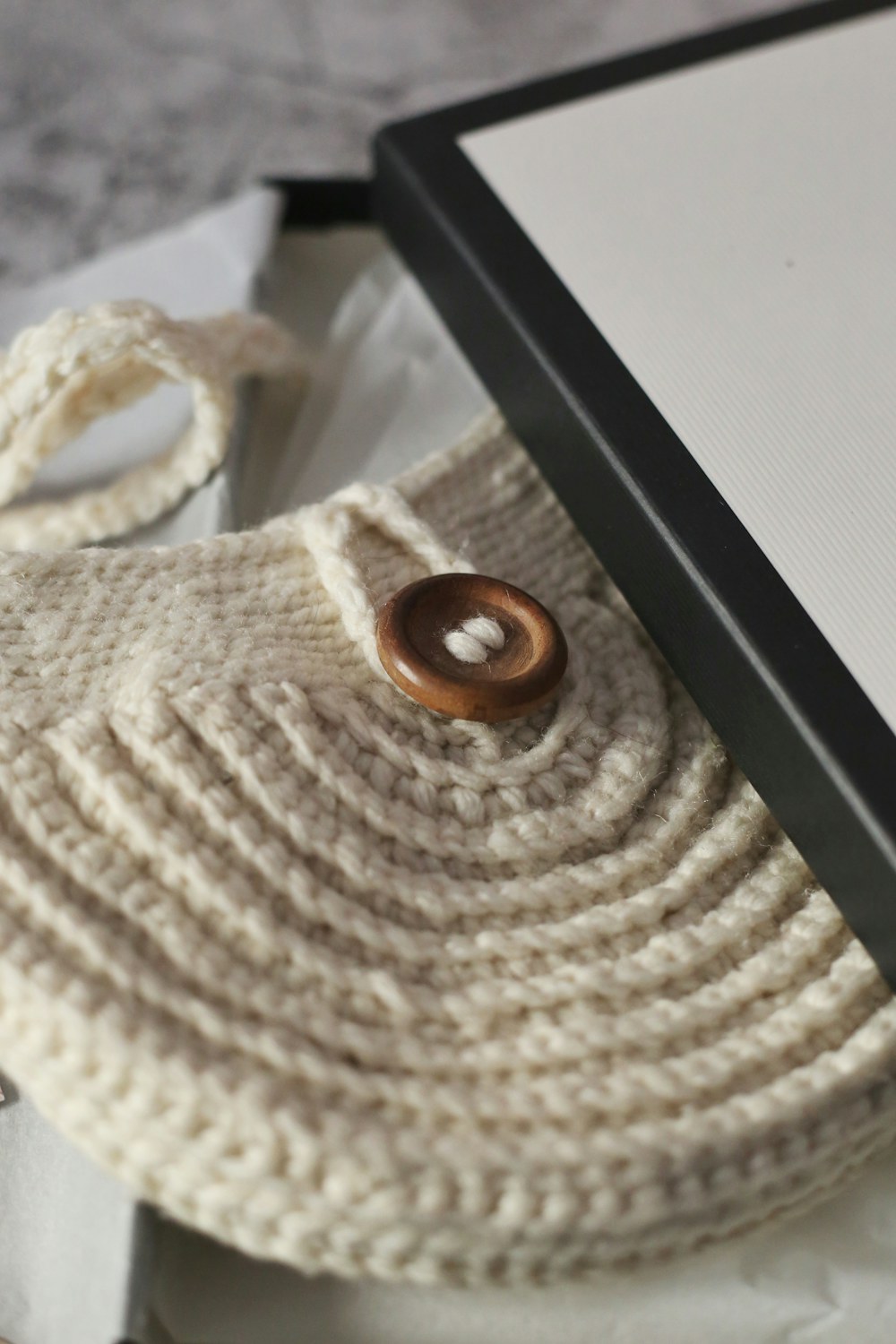 Handmade textured yarn pouch styled upright in a clean neutral setting