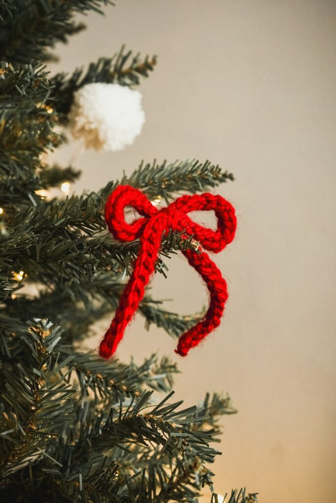 Handmade crochet ornament styled on a warm festive tree in natural light