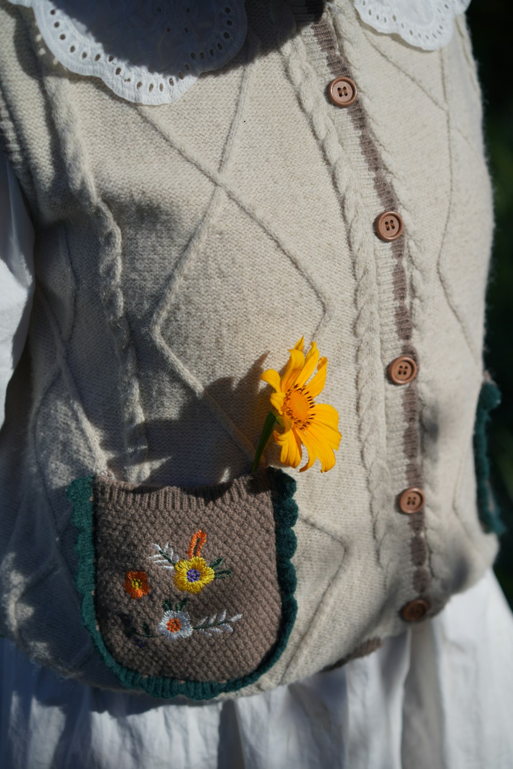 Handmade flower brooch attached to a soft neutral knit garment