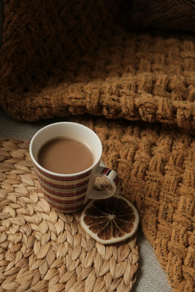 Warm cup on a handmade woven mat in a soft neutral tabletop scene