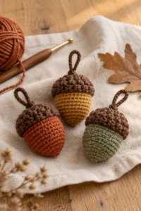 Handmade crochet acorn ornaments in warm autumn colors on a cozy neutral background